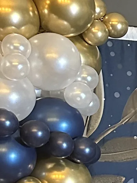Gold, pearl and navy balloons against a starry backdrop.