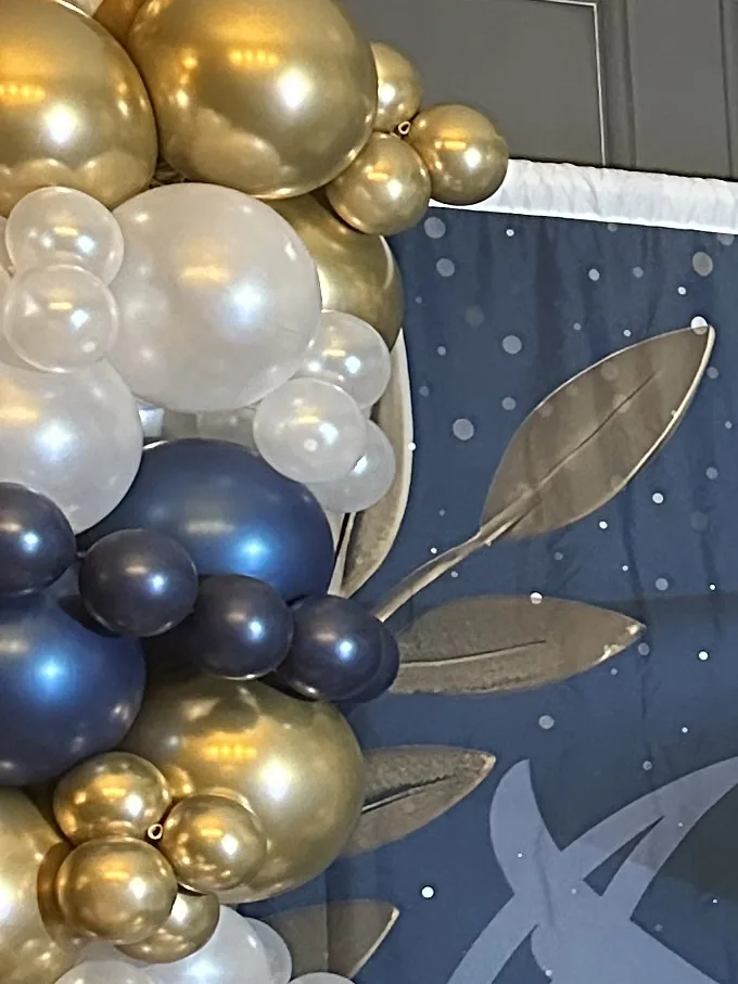 Balloon garland framing a starry event backdrop.