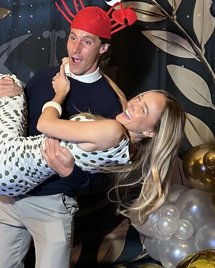 Two guests laughing in front of the booth's backdrop.